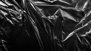 Captivating shot of a black plastic sheet, its smooth texture molded into various folds, creating an appealing play of light and shadows. photo