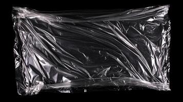 A tightly wrapped rectangular object in clear plastic, forms an abstract design of lines and shapes. The dark background enhances the plastic's transparency. photo
