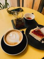 Coffee and Dessert Delight in a Cozy Caf Setting. Enjoy a serene moment with coffee and cheesecake in a vibrant caf atmosphere. vertical, film look photo