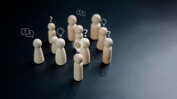 Questions and brainstorming, Wooden doll as person who have questions and need help solving the problems among crowd people, Business marketing and Creative solution concept. photo