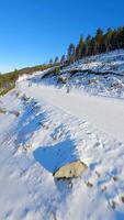 Smooth FPV flight over snowy mountain slope with people skiing and snowboarding. video