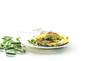 Egg omelette with herbs and vegetables isolated on white background photo