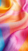Colorful silk fabric draped elegantly with a vibrant blend of hues in soft lighting photo