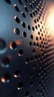 Close-up view of a perforated metal surface with warm lighting highlighting the textures and patterns photo