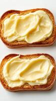 Slices of toasted bread topped with creamy butter on a white background photo