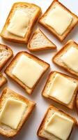 Slices of toasted bread topped with melting butter on a white background ready for a delicious meal photo