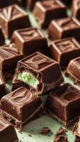 Mint-filled chocolate squares arranged on a green surface creating a tempting display of confectionery delight photo