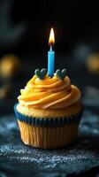 Vibrant cupcake with orange frosting and a blue candle lit for a special celebration photo