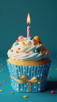 Colorful cupcake with frosting and candle on blue background for a festive celebration photo