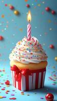 Colorful cupcake with a candle and sprinkles surrounded by festive decorations photo