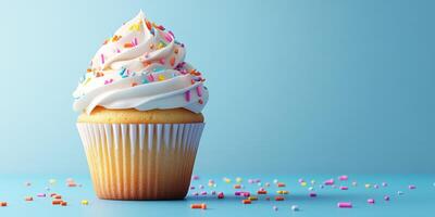 Delicious vanilla cupcake topped with creamy frosting and colorful sprinkles on a light blue background photo