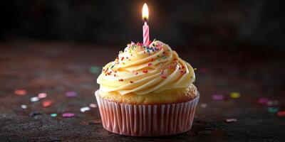 Delicious yellow frosted cupcake with a single pink candle and colorful sprinkles for a festive celebration photo