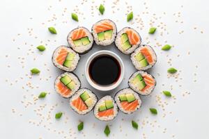 Sushi rolls arranged in a circle with soy sauce in the center. photo