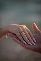 A womans hand with an engagement ring rests gently, the gemstone sparkling as a symbol of love and commitment. photo