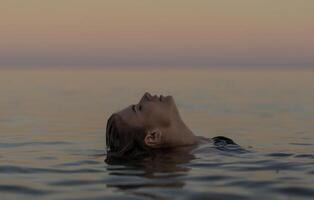 beautiful girl is relaxing in the sea, relaxing and taking care of herself. Profile portrait of a young woman floating in water, High quality photo. photo