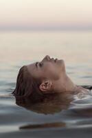 beautiful girl is relaxing in the sea, relaxing and taking care of herself. Profile portrait of a young woman floating in water. High quality photo