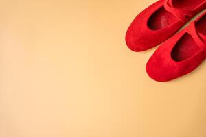 Red suede ballet flats on beige background with copy space photo