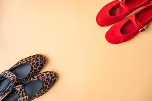 Leopard and red ballet flats on beige background with copy space photo