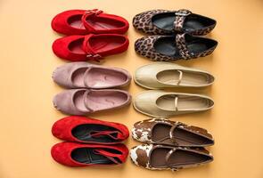 Flat lay of stylish ballet flats in various colors and patterns on pastel background. photo