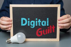 A man holds a sign that says Digital Guilt. Consequences of technology, social media overuse. Privacy concerns, and ethical issues in the digital age. photo