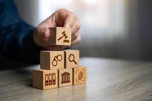 A man assembles a judicial system from blocks in the shape of a pyramid. Legal hierarchy, law enforcement, and justice system organization. photo