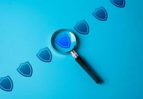 Magnifying glass and protective contour. Checking and monitoring the safety and inviolability of a physical, virtual or legal barrier. Collective security. Strength test. Cybersecurity photo