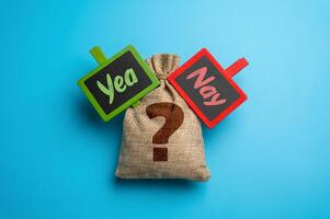 Bag with question and signs Yea or Nay. Voting, business choices, or financial investments. Consequences of selecting between two opposing paths photo