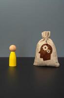 A bag of skills and intellectual abilities and a yellow human figurine. Concept of talent development, personal growth, knowledge acquisition, professional competence, and career potential. photo