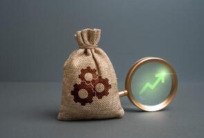 A bag of technical components and a green arrow pointing up. Concept of rising prices for parts, increasing volumes and quality of products. Market expansion, production scaling photo
