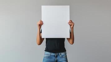 A person holding up a blank paper over their head photo
