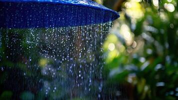 A blue umbrella is being sprayed with water photo