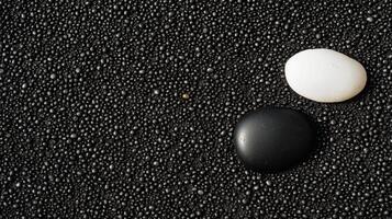Two stones on a black surface with white spots photo