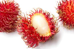 Fresh rambutan fruit split in half with white juicy pulp isolated on white background photo