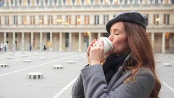 Close-Up of Parisian Girl with Coffee in Gray Beret and Coat, Camera in Motion video