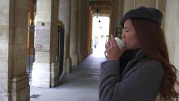 Girl in Beret Standing with Coffee Near Royal Palace Columns in Paris video