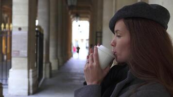 Close-Up of Girl in Beret with Coffee Near Royal Palace Columns in Paris video