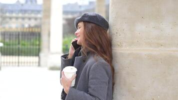 Girl with Coffee Talking on Phone Near Historic Columns in Paris video
