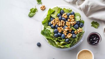 A beautifully arranged fresh salad with walnuts and berries, presented in a bright and modern setting. Grab-and-Go Salad. . photo
