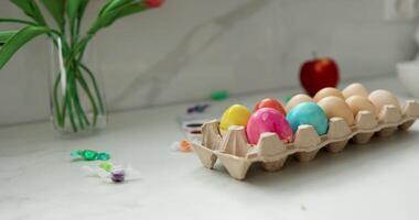 Colorful Easter eggs arranged on a kitchen counter, surrounded by fresh flowers video