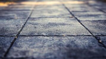Ground-level perspective showcasing textured pavement tiles in a neutral color palette, forming a geometric pattern with blurred edges. photo