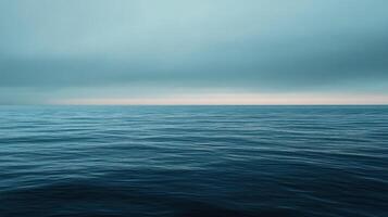 Vast expanse of open ocean waters with a serene blue sky. The horizon line blurs with the clouds creating a seamless and atmospheric scene. photo