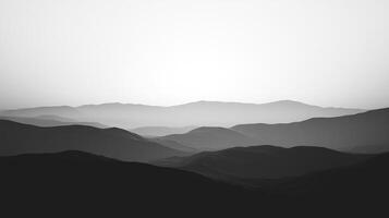 Monochromatic mountain range in grayscale featuring layers of peaks receding into a misty distance, evoking a sense of depth and serenity. photo