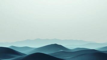 Blue toned rolling hills and distant mountains fade into a soft, muted sky. The cool color palette creates a calm atmosphere. photo