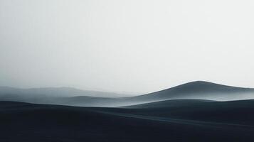 Mysterious monochromatic dunes under a serene, foggy sky invite contemplation. The rolling landscape creates a sense of peace and solitude. photo