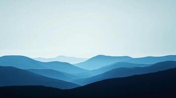 Serene mountain range fading into the horizon. Cool blues create a sense of depth and peace. The crisp sky hints at a clear day. photo