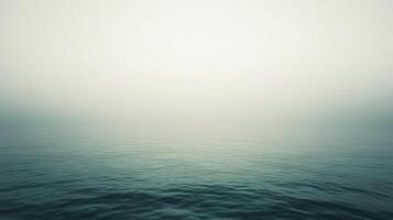 Mystical ocean waters under a hazy sky, waves ripple gently across the serene sea surface, creating a tranquil and dreamy atmosphere. photo