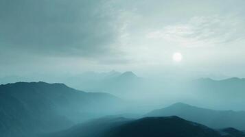 Ethereal mountain range landscape with peaks fading into a hazy, blue horizon under the soft glow of a muted sun in a serene atmosphere. photo