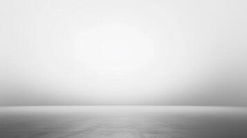 Monochromatic abstract background. The gray floor leads to a pale light. The image has a minimalist feel and muted color palette. photo