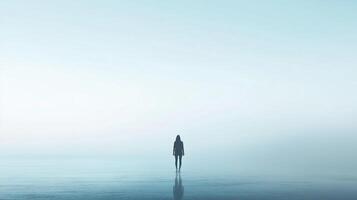 Solitude on the water's edge, a solitary figure stands gazing into the distance, blending with the misty horizon in serene introspection. photo