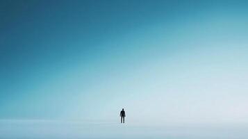 A solitary figure stands small against the vast expanse of a tranquil, minimalist landscape, creating a sense of serenity and isolation. photo